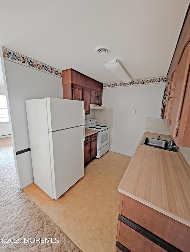 kitchen featuring white appliances, sink, and decorative backsplash