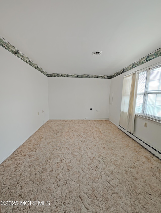 unfurnished room with baseboard heating and light carpet