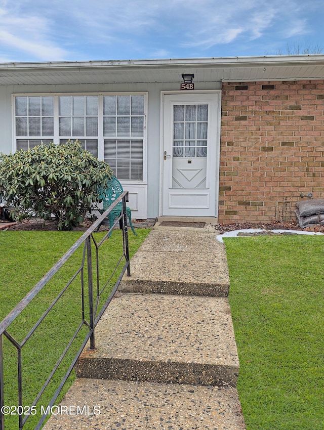 doorway to property featuring a lawn