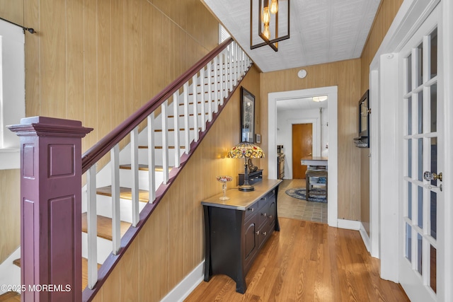 stairway with hardwood / wood-style flooring and wooden walls