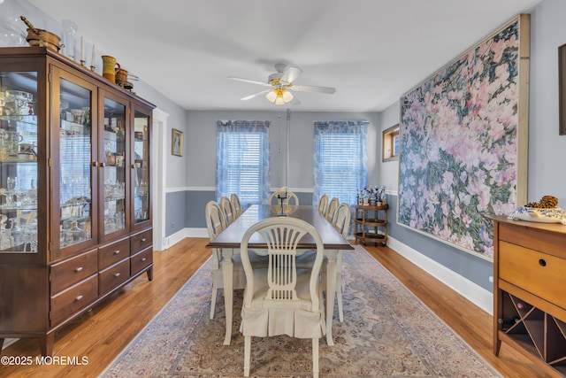 dining space with hardwood / wood-style floors and ceiling fan