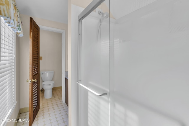 bathroom with toilet, vanity, and a shower with shower door