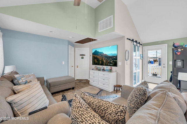 living room featuring ceiling fan, a barn door, and high vaulted ceiling