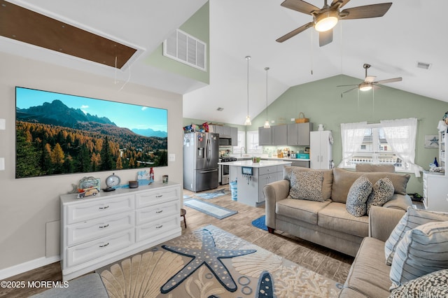 living room featuring lofted ceiling, sink, ceiling fan, and light wood-type flooring