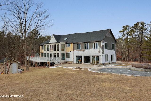 back of property with a sunroom and a storage unit