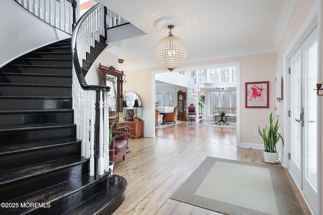 foyer featuring crown molding, a chandelier, french doors, and hardwood / wood-style flooring