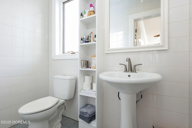 bathroom featuring tile walls and toilet