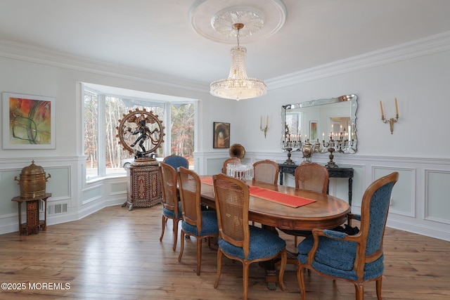 dining space with crown molding and hardwood / wood-style floors