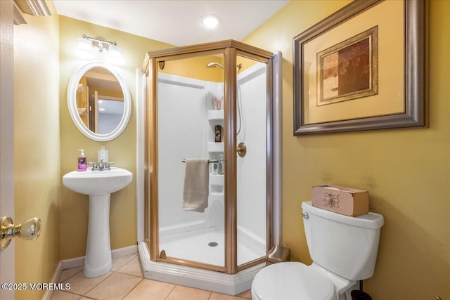 bathroom featuring tile patterned floors, toilet, a shower with shower door, and sink