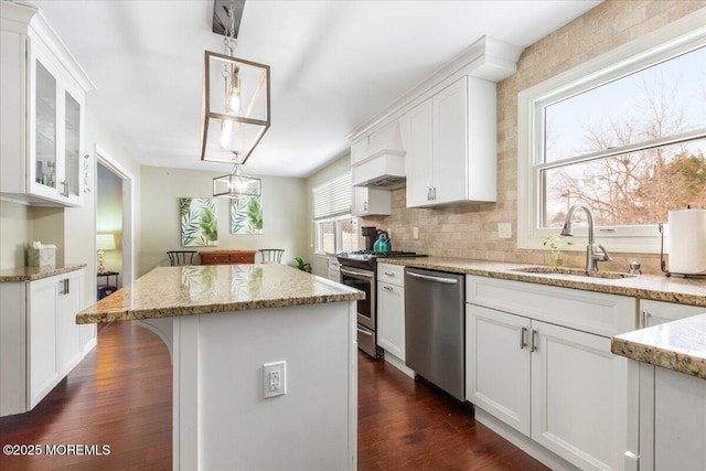 kitchen featuring sink, decorative light fixtures, stainless steel appliances, and white cabinets