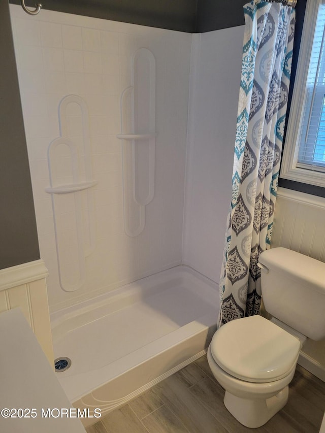 bathroom featuring a shower with curtain, wood-type flooring, and toilet