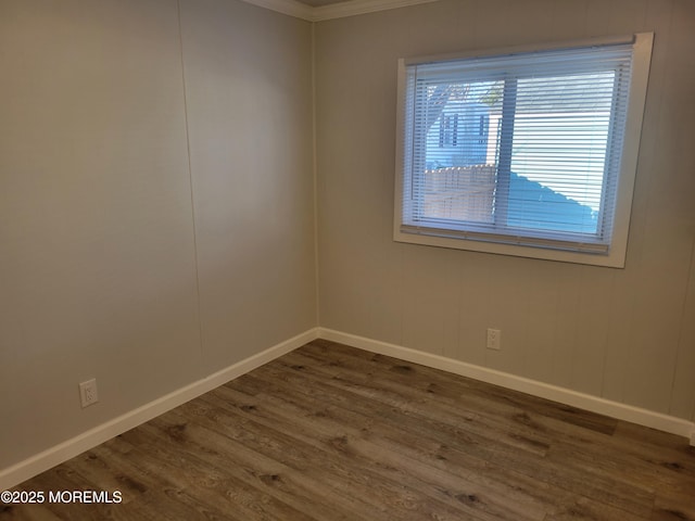 unfurnished room with dark wood-type flooring and ornamental molding