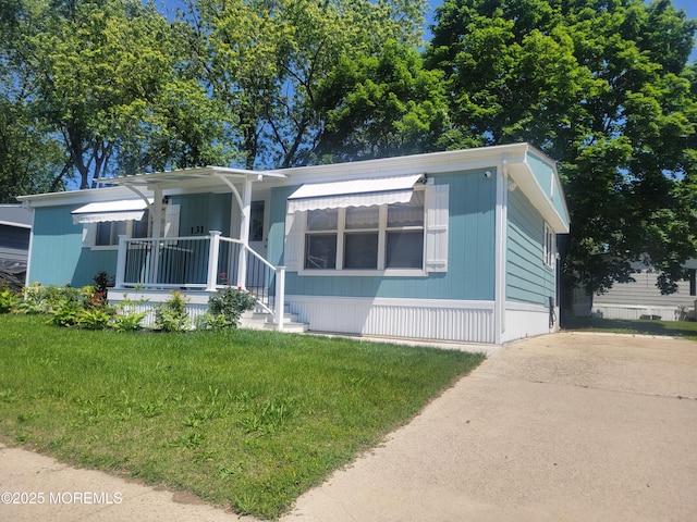 131 Douglas Dr, Jackson, NJ 08527 - manufactured / mobile home featuring a front yard, covered porch, and concrete driveway