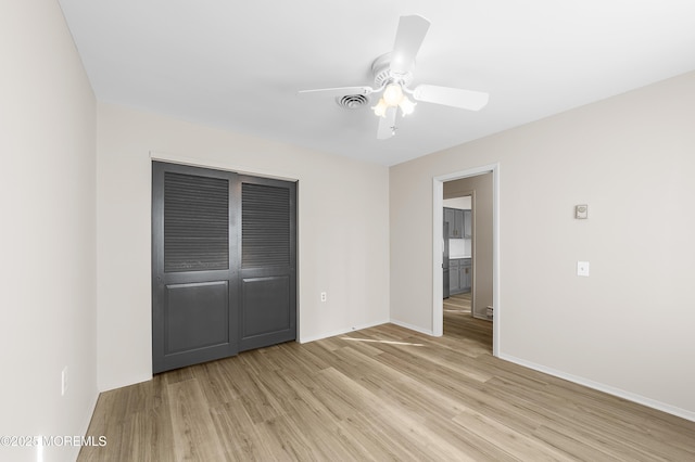 unfurnished bedroom featuring light hardwood / wood-style flooring, ceiling fan, and a closet