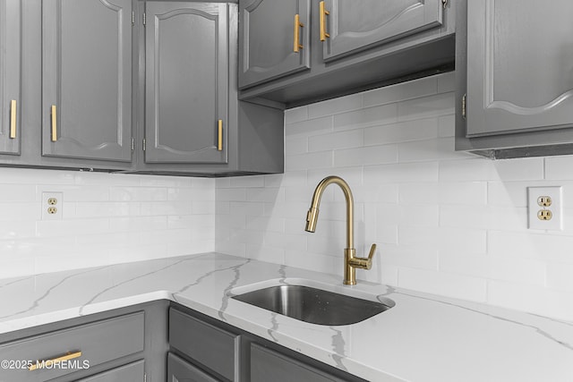 kitchen with sink, decorative backsplash, and gray cabinetry