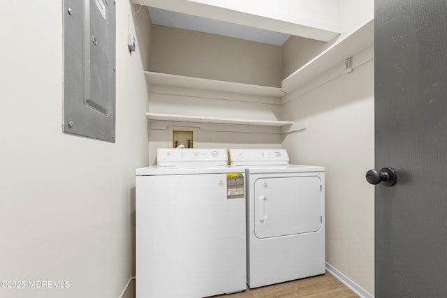 washroom with separate washer and dryer, electric panel, and light wood-type flooring