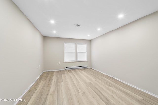 empty room with a baseboard radiator and light wood-type flooring