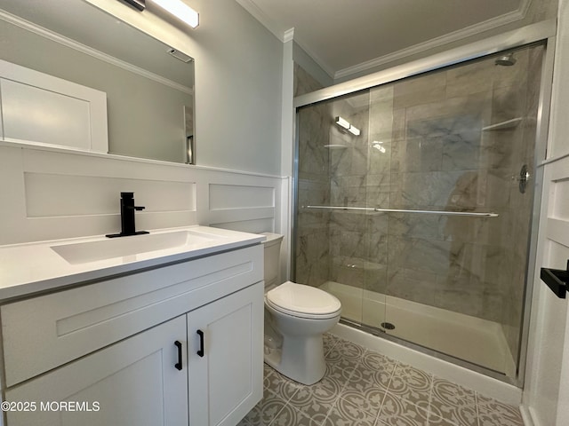 bathroom featuring vanity, a shower with shower door, ornamental molding, and toilet