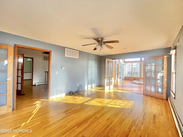 empty room with light hardwood / wood-style flooring, french doors, ceiling fan, and baseboard heating