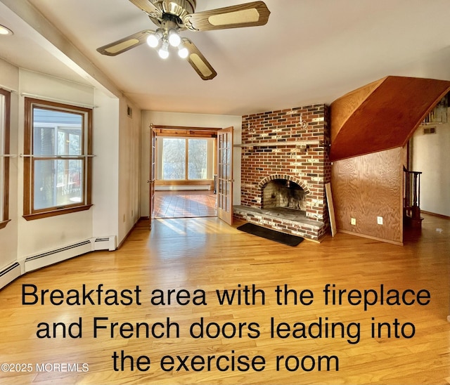 unfurnished living room with baseboard heating, ceiling fan, hardwood / wood-style floors, and a brick fireplace