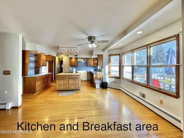 living room with sink, light hardwood / wood-style floors, ceiling fan, and baseboard heating