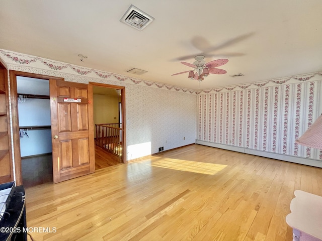 unfurnished bedroom with ceiling fan, light hardwood / wood-style floors, and a baseboard radiator