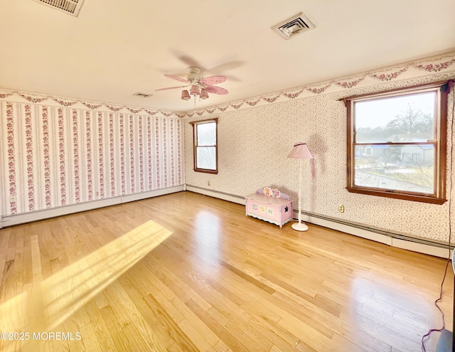 unfurnished bedroom with hardwood / wood-style flooring, ceiling fan, and baseboard heating