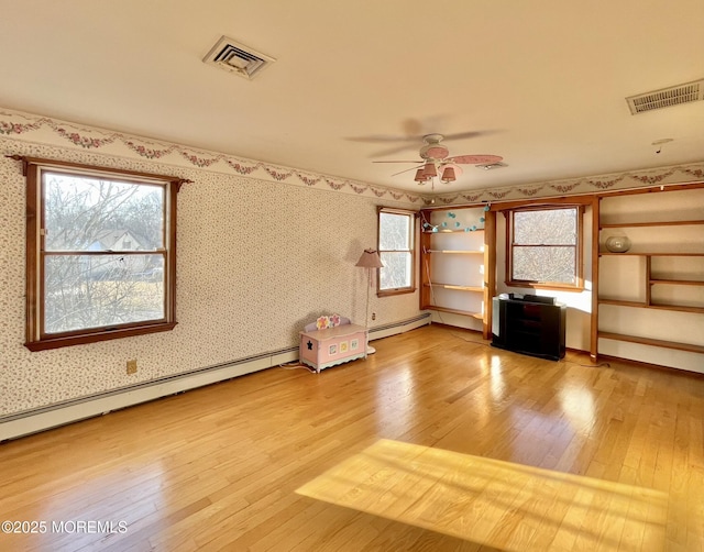 unfurnished room featuring ceiling fan, a baseboard radiator, and wood-type flooring