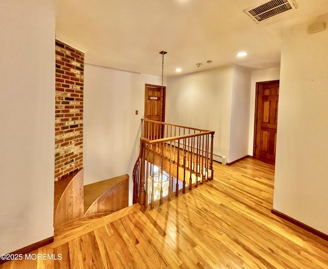 corridor featuring a baseboard radiator and light wood-type flooring