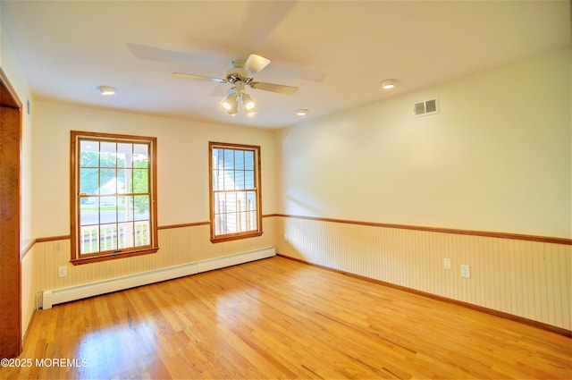 705 Princeton Rd, Lanoka Harbor, NJ 08734 - spare room with a baseboard radiator, wood finished floors, a wainscoted wall, and a ceiling fan