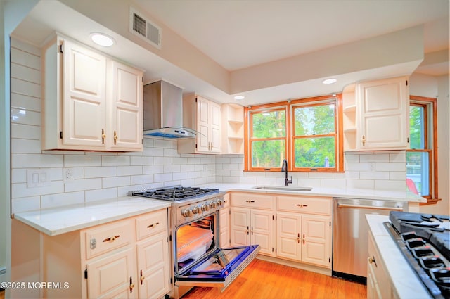 705 Princeton Rd, Lanoka Harbor, NJ 08734 - kitchen with appliances with stainless steel finishes, open shelves, wall chimney exhaust hood, a sink, and light wood-style floors