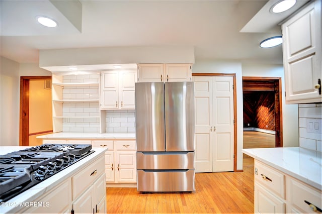 705 Princeton Rd, Lanoka Harbor, NJ 08734 - kitchen with freestanding refrigerator, black gas stovetop, light wood-style flooring, tasteful backsplash, and white cabinets