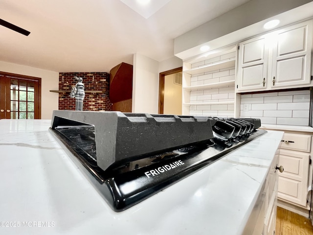 705 Princeton Rd, Lanoka Harbor, NJ 08734 - kitchen view of tasteful backsplash, white cabinetry, light wood-style floors, and light stone countertops