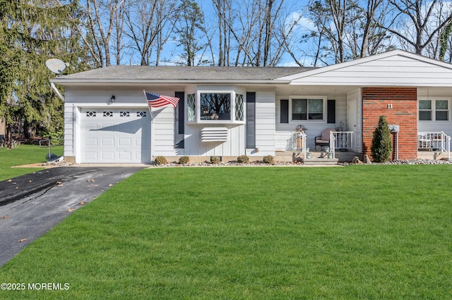 ranch-style home featuring a garage, covered porch, and a front yard