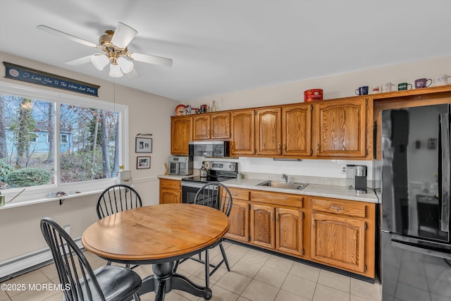 kitchen featuring light tile patterned flooring, lofted ceiling, sink, appliances with stainless steel finishes, and ceiling fan