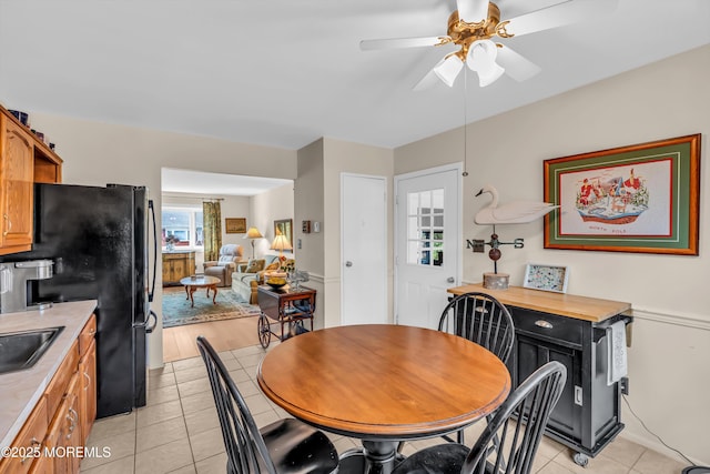 dining room featuring light tile patterned flooring, ceiling fan, and sink