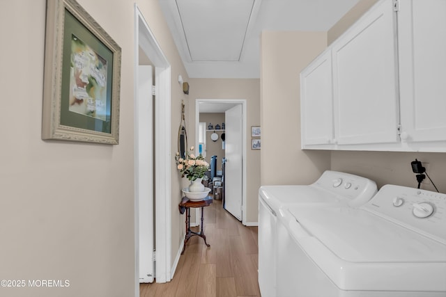 washroom with cabinets, washer and clothes dryer, and light hardwood / wood-style floors