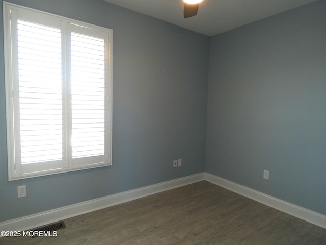 spare room featuring ceiling fan, plenty of natural light, and dark hardwood / wood-style flooring