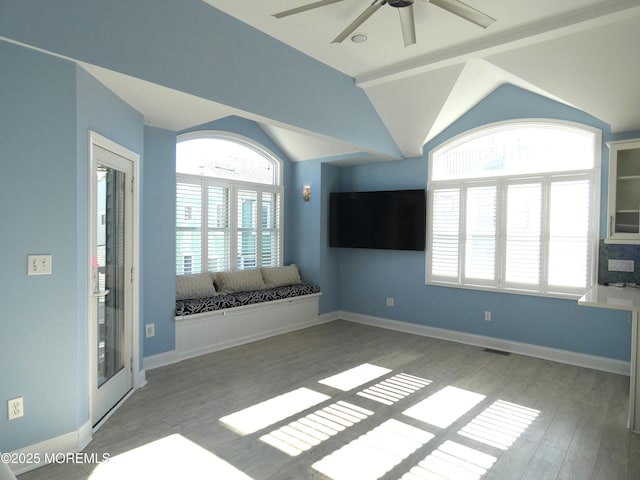 spare room with hardwood / wood-style flooring, vaulted ceiling, and ceiling fan