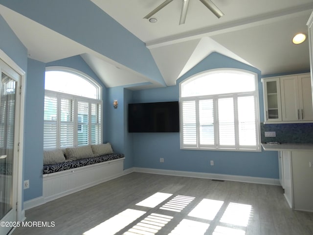 unfurnished living room featuring vaulted ceiling with beams, hardwood / wood-style flooring, and ceiling fan