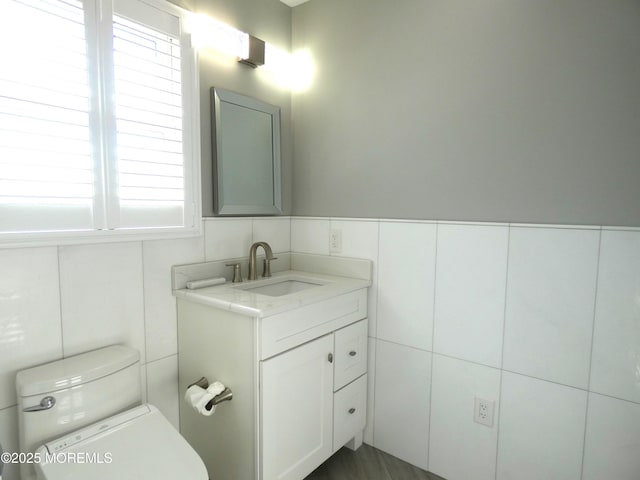 bathroom with vanity, a wealth of natural light, tile walls, and toilet