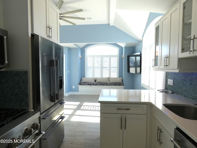 kitchen with white cabinetry, decorative backsplash, light hardwood / wood-style flooring, and stainless steel appliances