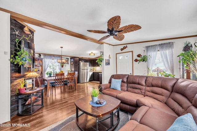 living room with ceiling fan, ornamental molding, and wood-type flooring