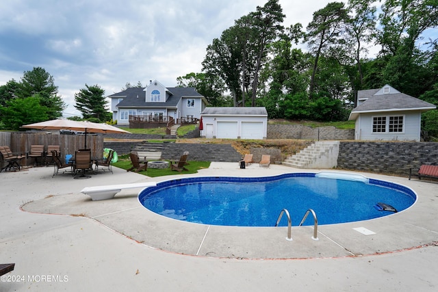 view of pool with an outdoor fire pit, an outdoor structure, a diving board, a fenced in pool, and a patio area