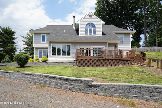 rear view of property with a shingled roof, fence, a deck, and a yard