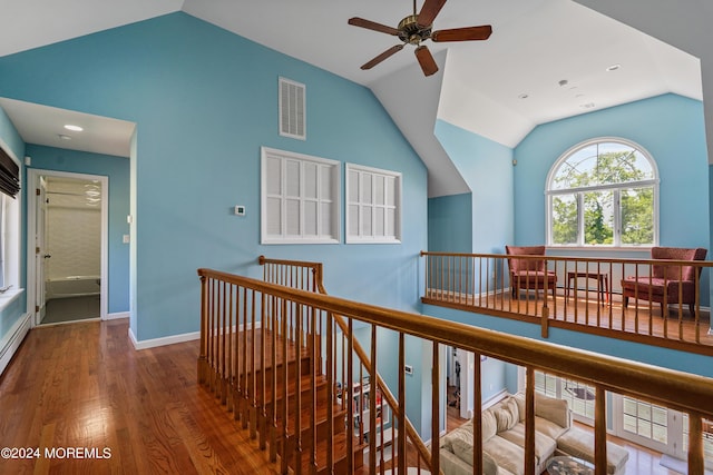 hallway featuring lofted ceiling, an upstairs landing, wood finished floors, and visible vents