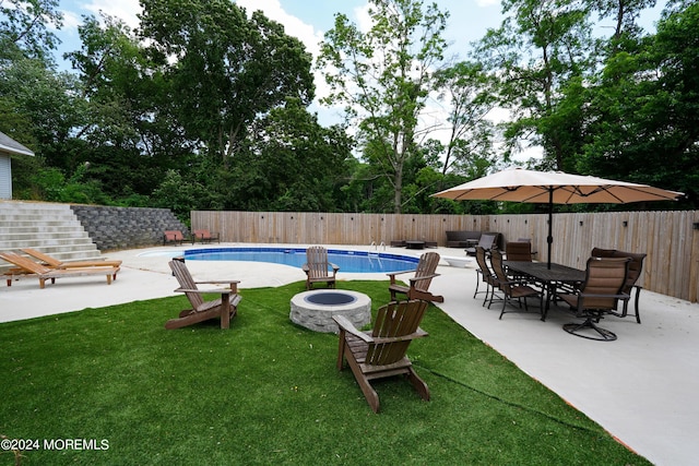 view of swimming pool with a fenced in pool, a patio, a lawn, a fenced backyard, and a fire pit