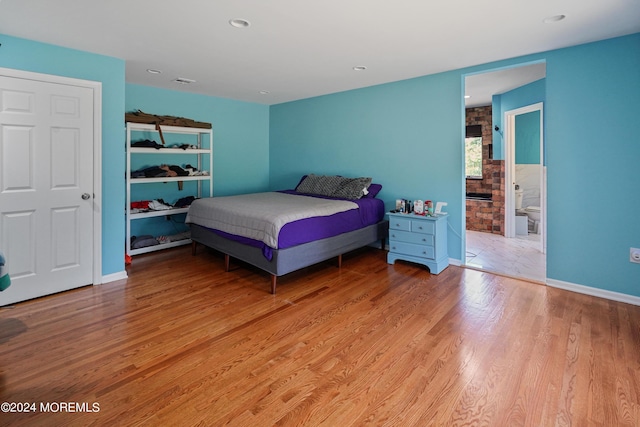 bedroom featuring baseboards, wood finished floors, and recessed lighting