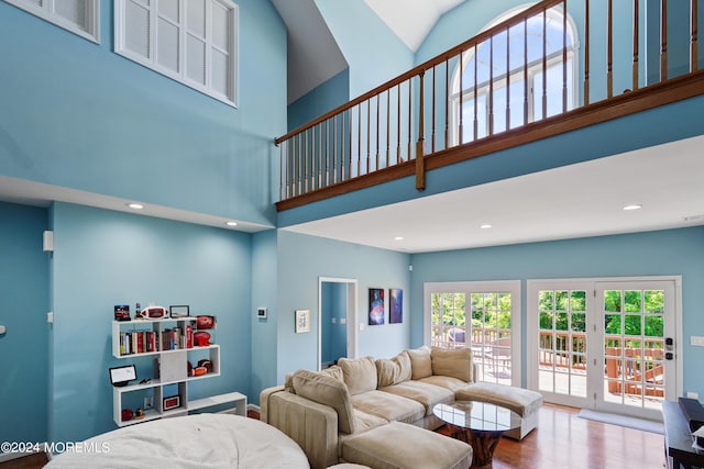 living room featuring wood finished floors, a towering ceiling, and recessed lighting