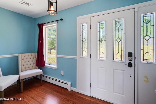 entrance foyer with baseboard heating, wood finished floors, visible vents, and baseboards